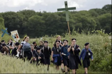 Jovens seguram cruzes ao chegarem para a missa na tradicional peregrinação de Pentecostes de Paris a Chartres em 2025