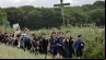 Jovens seguram cruzes ao chegarem para a missa na tradicional peregrinação de Pentecostes de Paris a Chartres, em Sonchamp, perto de Paris, no último domingo (8).